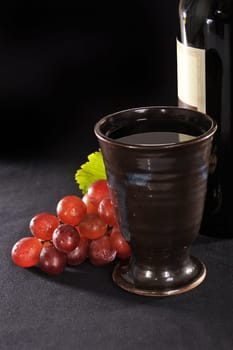 Grapes,wine bottle and goblet on black background