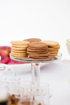 Closeup of four stacks of dry biscuits on glass serving stand