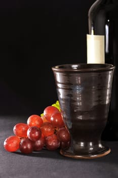 Grapes,wine bottle and goblet on black background
