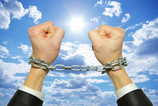 Hands in chains on a background sky
