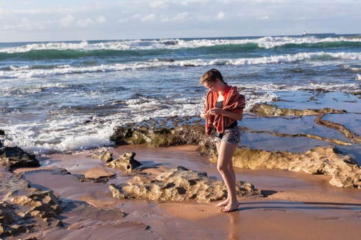 Girl teenager daughter exploring ocean beach sand rock reefs pools at low tide