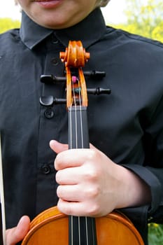 Young man with violin in the rapefield