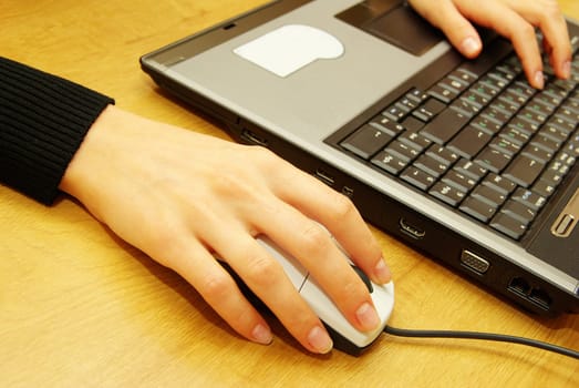 Female hands typing on laptop keyboard