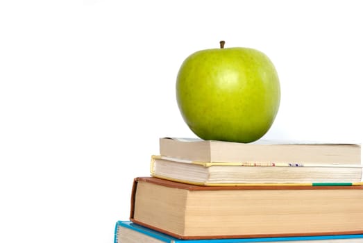 Green apple and stack of books for school