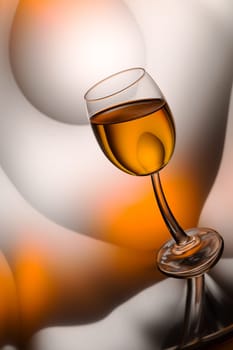 Glass of cognac in a distorted reflection.