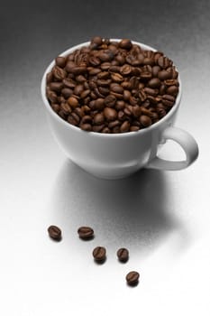 White coffee cup full of grain on textured steel surface