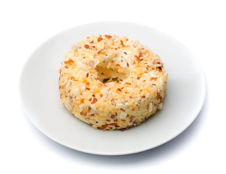 Round sweet cheese with nuts and pineapple on a plate. Isolate on white.