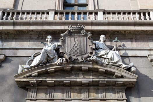 Two maidens on the facade of an old building in Barcelona, Spain.