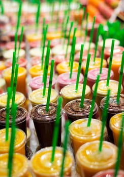 Plastic cups with fresh cocktails and tubes.