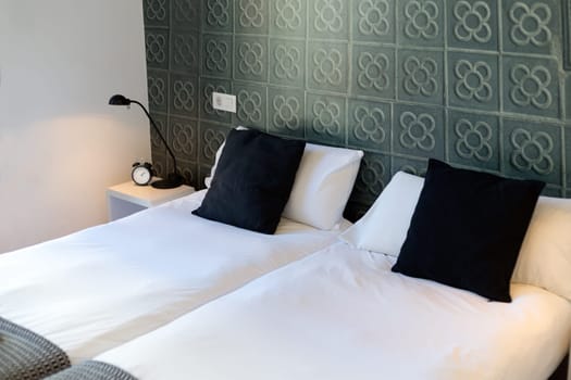 Bedroom interior modern hotel bed with a candlestick in mixed lighting.