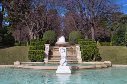 Fountain in the park on a background of the fence.