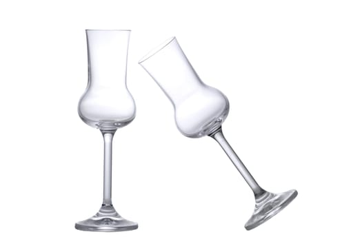Two empty Grappa glasses one tilted one standing