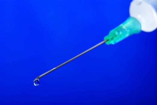Drop on syringe needle macro on blue