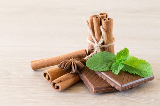 Mint with cinnamon on wood background