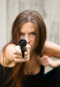 Woman crouches and prepares to fire second shot at assailant