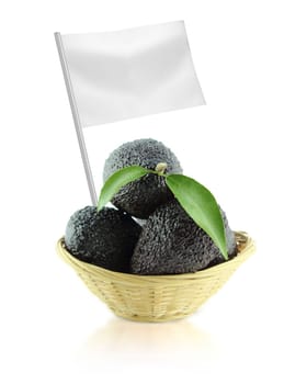 Healthy and organic food concept. Fresh Avocados with leaves on a Dish of straw with flag showing the benefits or the price of fruits.