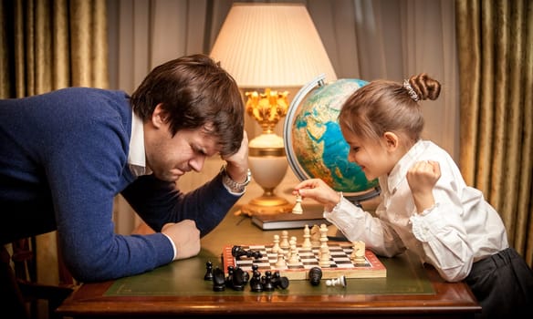 Photo of little girl won chess at man