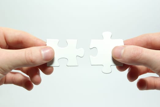 Hands holding two  puzlle for joining