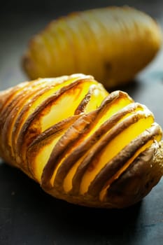Sliced foil baked jacket potato cooked on a summer BBQ, close up view of the texture of the sliced vegetable ready to be served