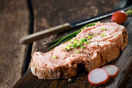 Open rye sandwich with smoked teewurst, a German sausage made of ground pork and bacon, topped with freshly chopped chives, black pepper and radish