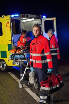 Confident paramedic with team assisting injured patient during road accident