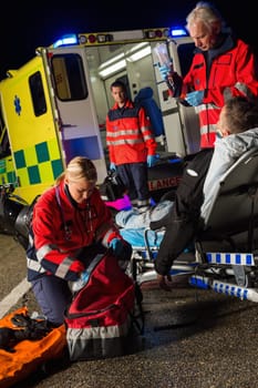 Paramedic team assisting injured motorbike man driver at night