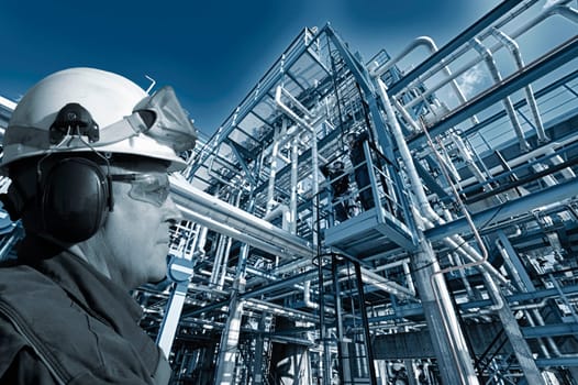 oil and gas workers inside large petrochemical refinery, pipelines and towers
