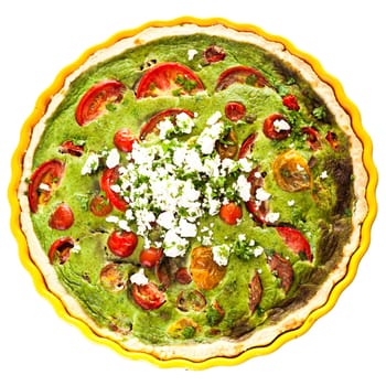 Healthy tasty vegetarian quiche in a decorative fluted pie plate isolated on white with a clipping path, overhead view