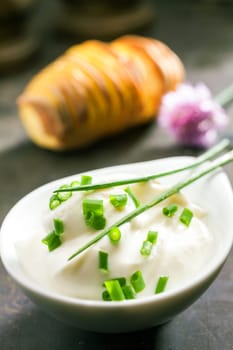 Plate of chopped fresh chives with two whole leaves ready to be used as a flavoring in salad or a garnish in cooking