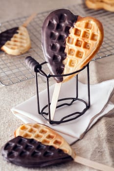 Chocolate coated golden waffle heart popsicles on a stick for a romantic Valentines or anniversary treat
