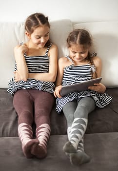 Happy two girls looking on tablet screen