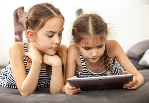 Portrait of concentrated young girls using digital tablet