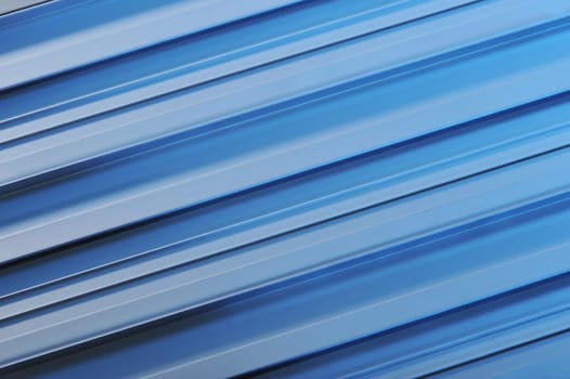 abstract background made of aluminium profile strips in blue light