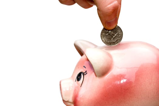 Hand inserting coin into piggy bank isolated on white