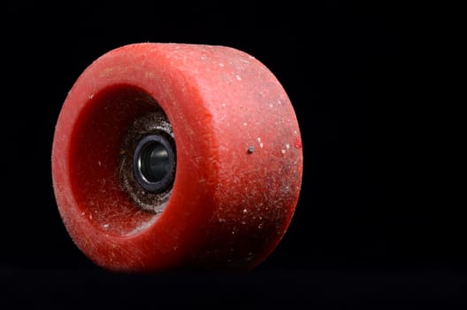 Old Vintage Consumed Skate Wheel on a Black Background