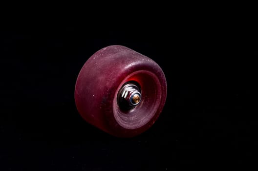 Old Vintage Consumed Skate Wheel on a Black Background