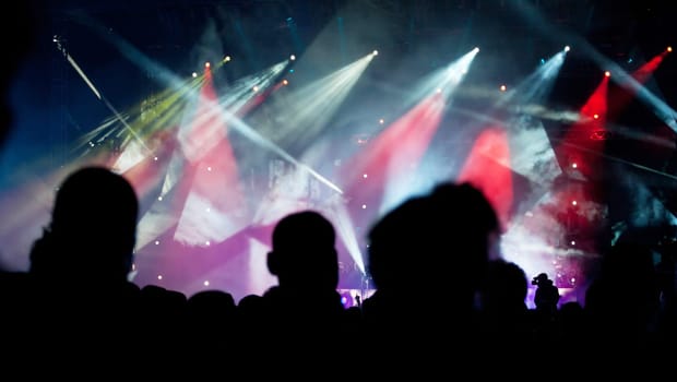Cheering crowd in front of bright colorful stage lights
