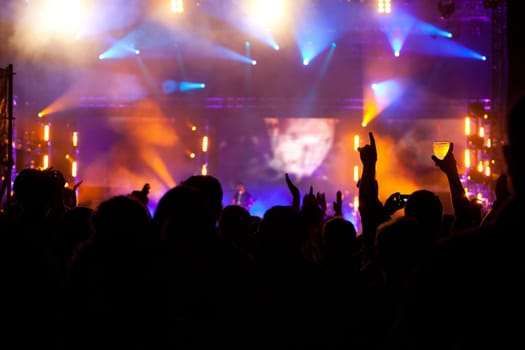 Cheering crowd in front of bright colorful stage lights