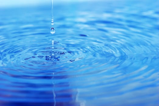The round transparent drop of water falls downward