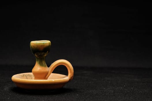 Colorful designed clay vase over a Black background