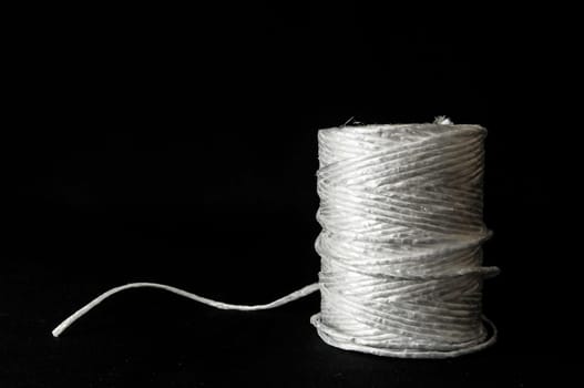Roll of White Twine on a Black Background