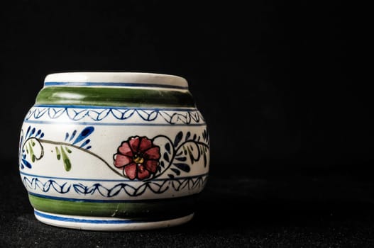 Colorful designed clay vase over a Black background