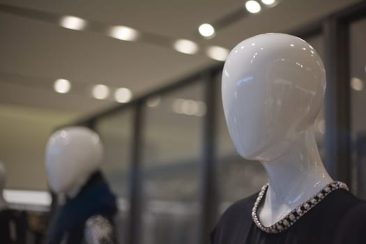 Boutique with mannequins without face in fashionable dresses