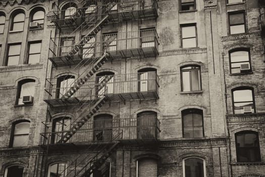 Vintage photo of old building with outdoor staircase (New York City, USA). Horizontally.