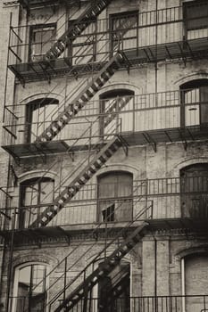 Vintage photo of old building with outdoor staircase (New York City, USA).Vertically.