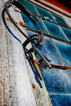 old, antique keys hanging on a stained-glass leaded window frame