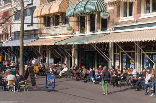 people enjoying the nice weather on terraces in the center of The Hague. The Hague is the third city in the Netherlands with over 500,000 residents
