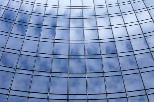 The photograph of cloud reflections in the windows of a high-rise facade.