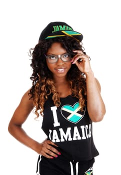 A pretty Jamaican woman in exercise outfit and a cap on her long.black and brown hair standing isolated for white background..