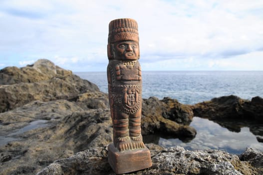 Ancient Maya Statue on the Rocks near the Ocean